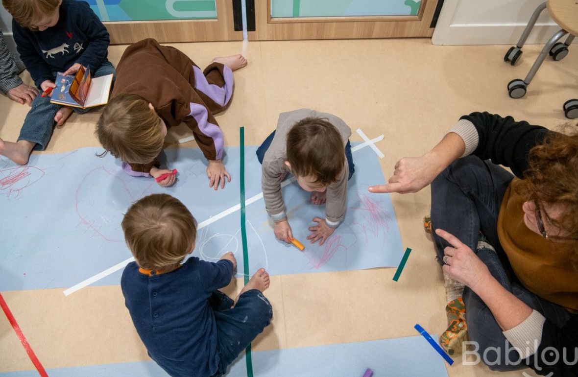 Une pro en crèche jouant avec un groupe d'enfants