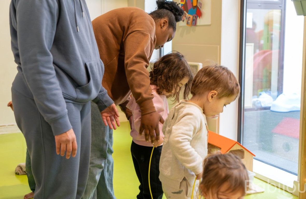 Deux pros en crèche Babilou avec un groupe d'enfants