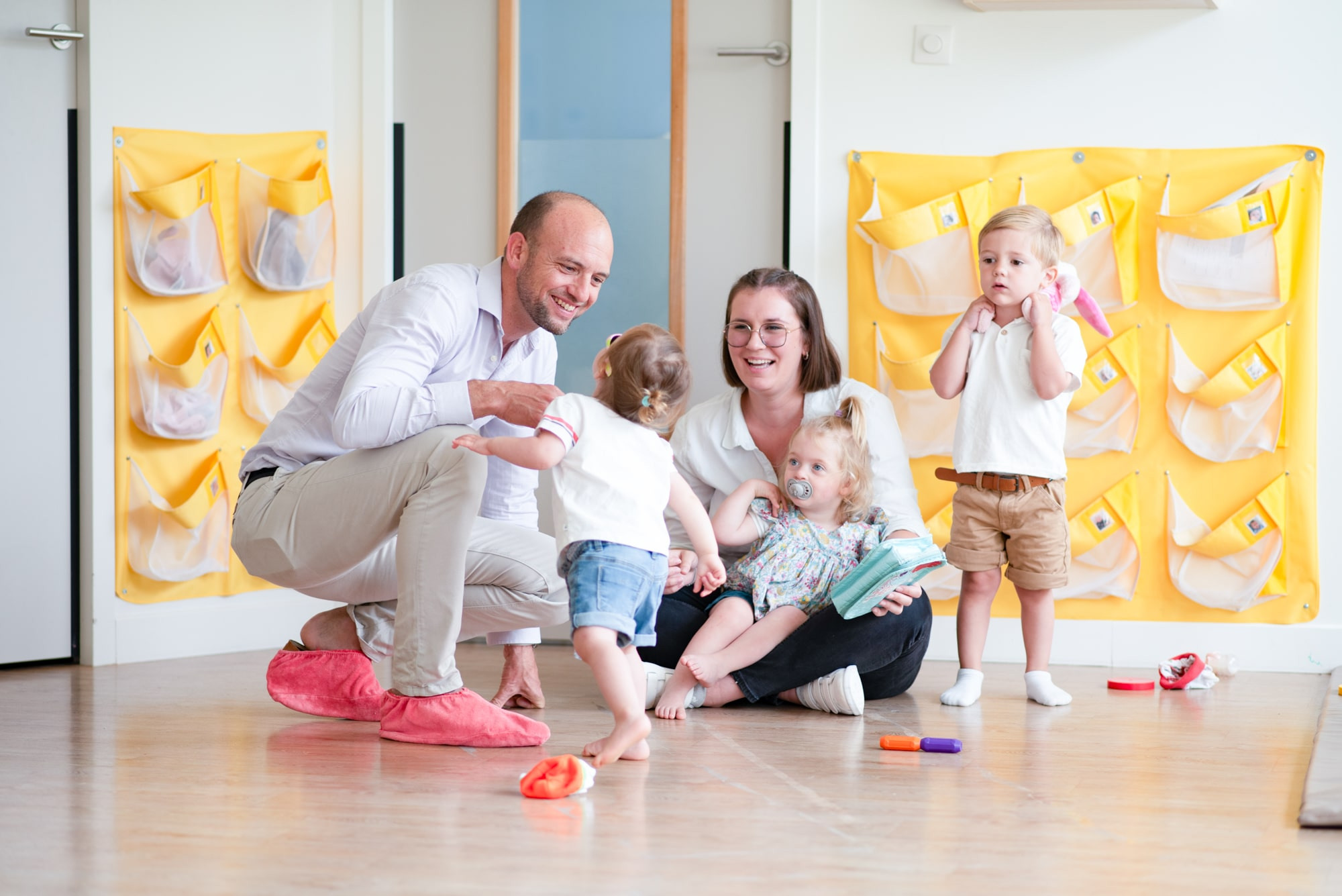 Un parent, une professionnelle et des enfants discutent en crèche Babilou