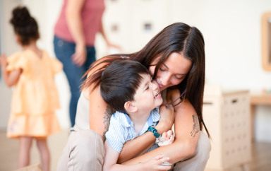Une professionnelle de crèche fait un câlin à un enfant