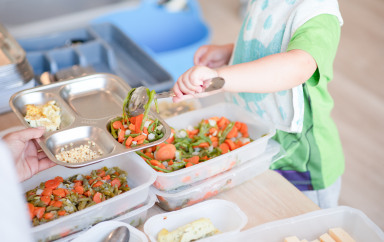 Enfant en train de se servir à manger en crèche Babilou