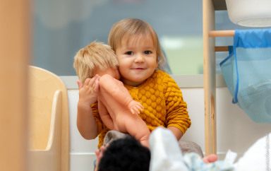 Enfant jouant avec une poupée au sein de la crèche