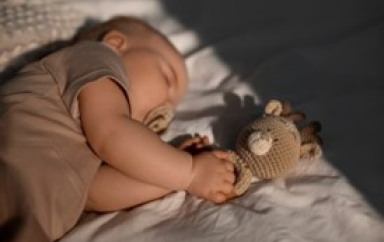 Un bébé qui dort avec une peluche 