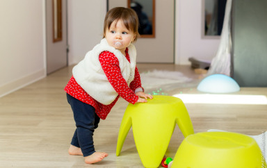 Un enfant qui s'appuie sur un tabouret 