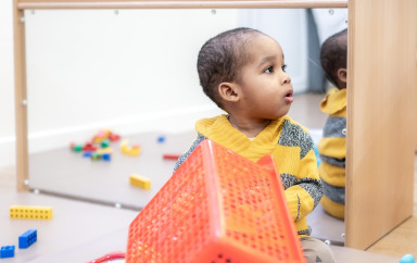 Un enfant assit entouré de jouets