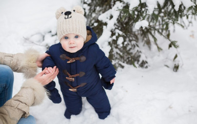 Bébé debout sur de la neige 