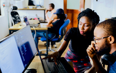 un homme et une femme en train de travailler sur un pc