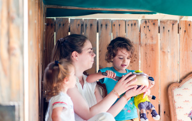 enfant qui sont encadrés par une adulte dans le jeu en extérieur