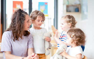 Professionnelle en crèche discutant avec un groupe d'enfants