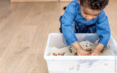 Enfant en train de jouer avec un bac sensoriel