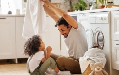 Parent fait lessive avec son enfant