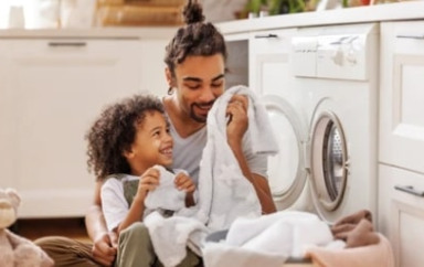 Parent qui fait la lessive avec son enfant