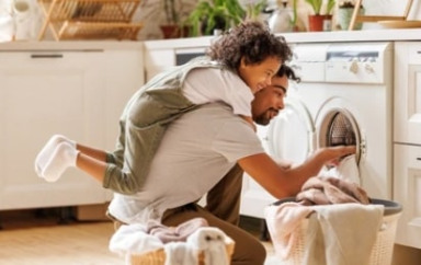 Parent joue avec son enfant pour la lessive