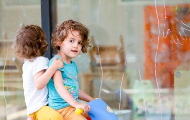 Deux enfants sur un vélo à l'extérieur de la crèche Babilou