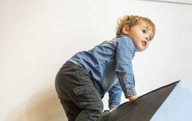 Un enfant en train de grimper sur un tapis en crèche Babilou