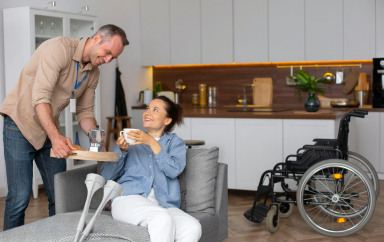 Un homme apporte de l'eau à une femme avec deux béquilles 