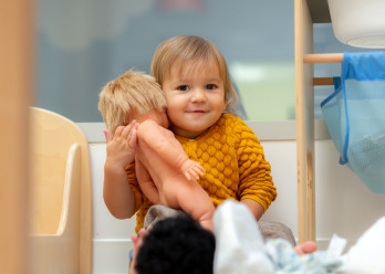 Enfant jouant avec une poupée au sein de la crèche