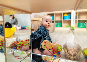 Enfant jouant avec un jouet à boules au sein de la crèche de Montrouge