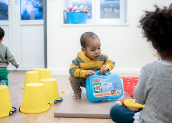 Enfant jouant avec un jouet bleu au sein de la crèche Babilou Montrouge 