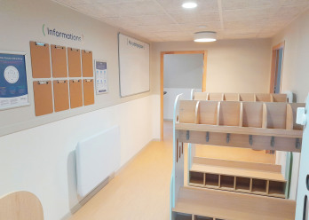 Hall d'accueil avec mur d'informations famille au sein de la crèche Babilou Poissy Paix