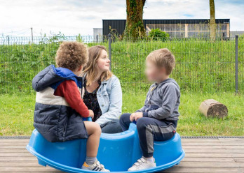 Enfants jouant à l'extérieur de la creche Babilou Chateaubourg Cugnot accompgné d'une professionnelle