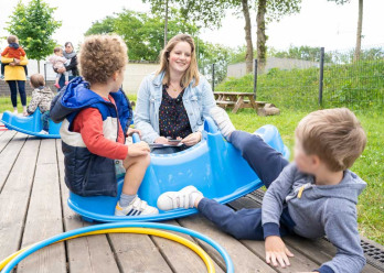 Enfants et professionnelle jouant ensemble dehors au sein de la creche Babilou Chateaubourg Cugnot