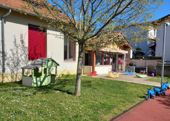 Pelouse et tricycles dans le jardin de la micro-crèche Babilou Eveux Eglise