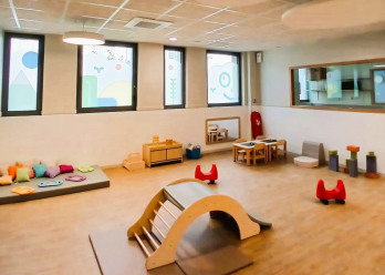Vue large et lumineuse de la salle d'éveil au sein de la crèche Babilou Nogent Sémard