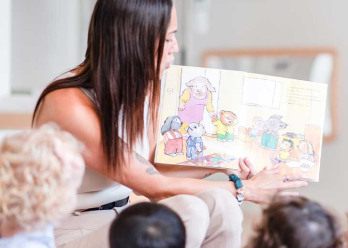 Professionnelle en crèche entourée d'enfant rigolant