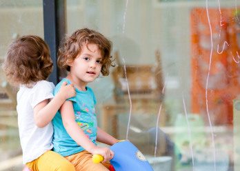 Deux enfants sur un vélo à l'extérieur de la crèche Babilou