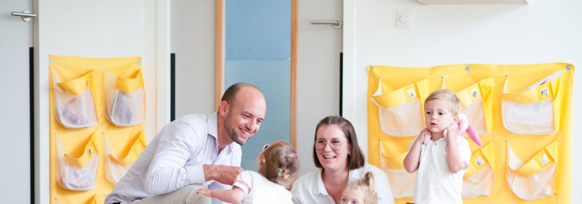Un parent, une professionnelle et des enfants discutent en crèche Babilou
