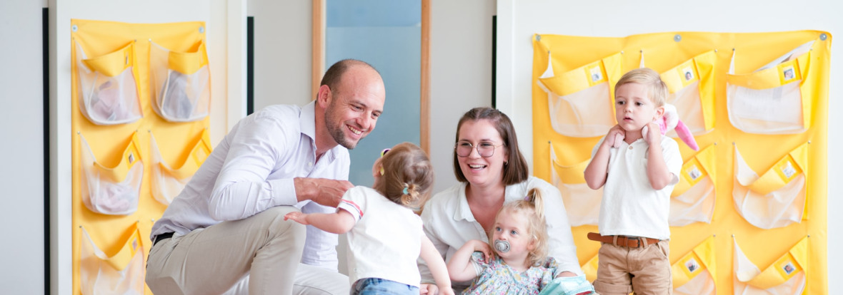 Un parent, une professionnelle et des enfants discutent en crèche Babilou