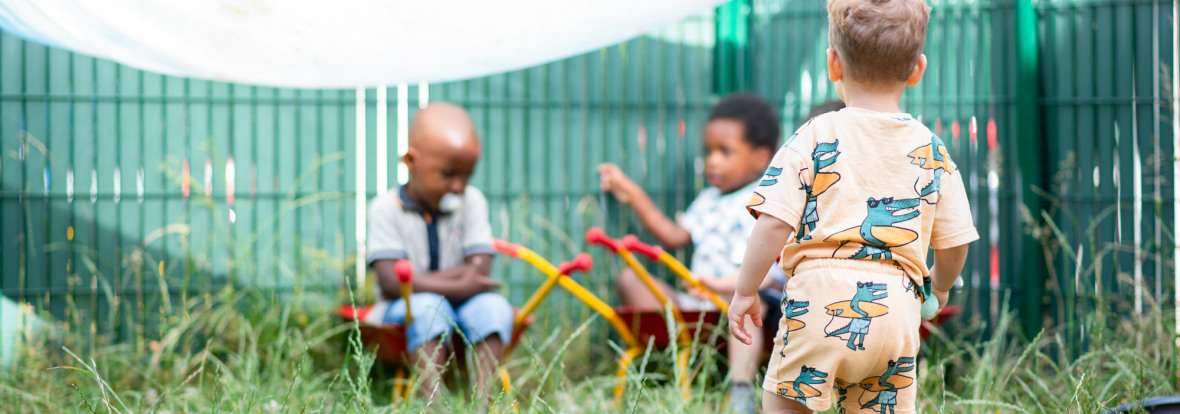 Trois enfants en train de jouer dans le jardin d'une crèche Babilou