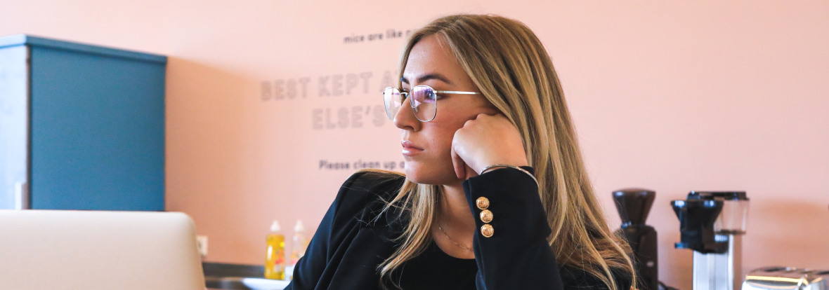 Jeune fille pensive, travaillant à domicile, devant son ordinateur portable