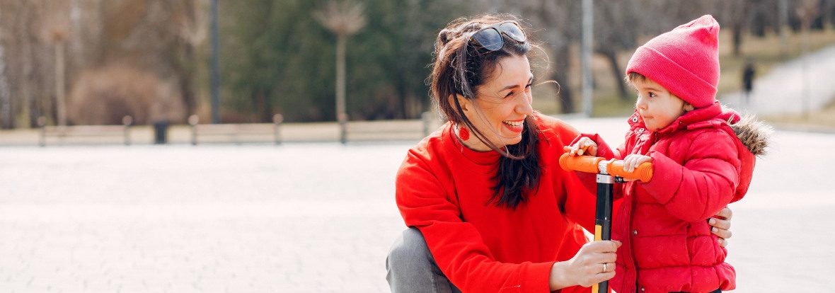Une femme avec sa fille sur une trottinette à 3 roues