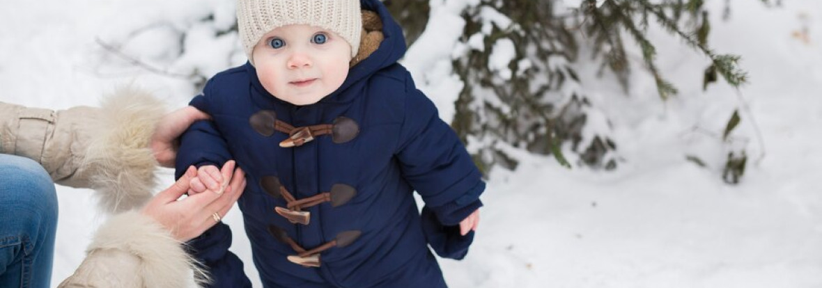 Bébé debout sur de la neige 