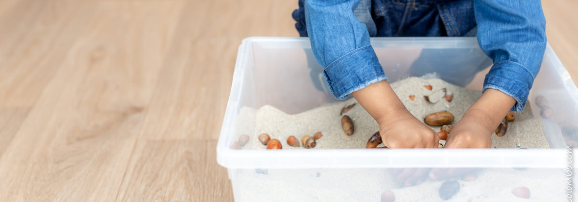 Enfant en train de jouer avec un bac sensoriel