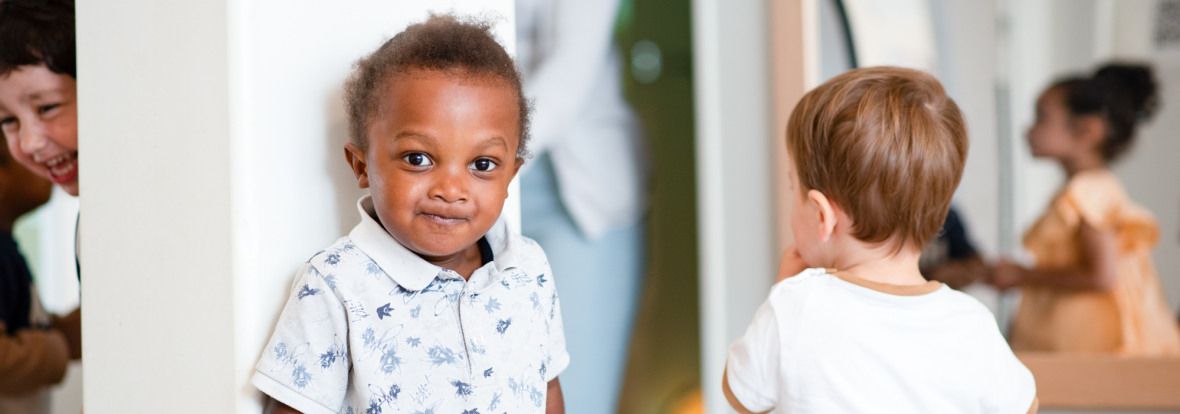Enfant en crèche, au milieu d'un autre groupe d'enfants