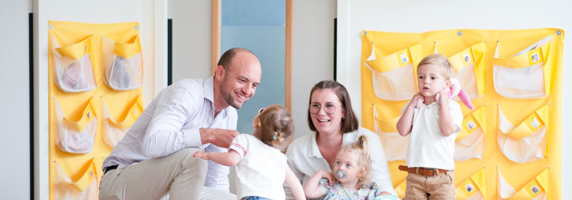 Un papa et son enfant, avec un professionnel de crèche en crèche