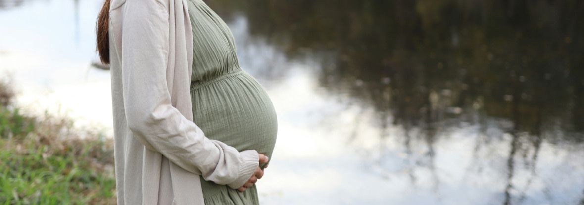 Femme enceinte, au bord d'une rivière