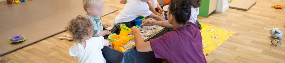 Un groupe d'enfant en crèche durant une activité accompagné d'une professionnelle 