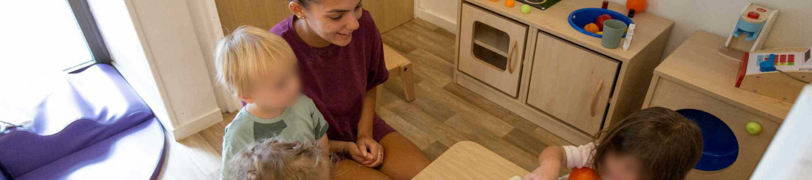 Une professionnelle en crèche Babilou avec un groupe d'enfant 