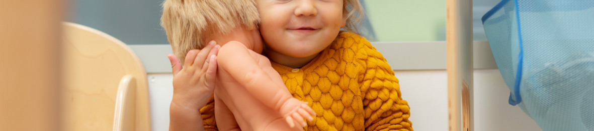 Enfant jouant avec une poupée au sein de la crèche