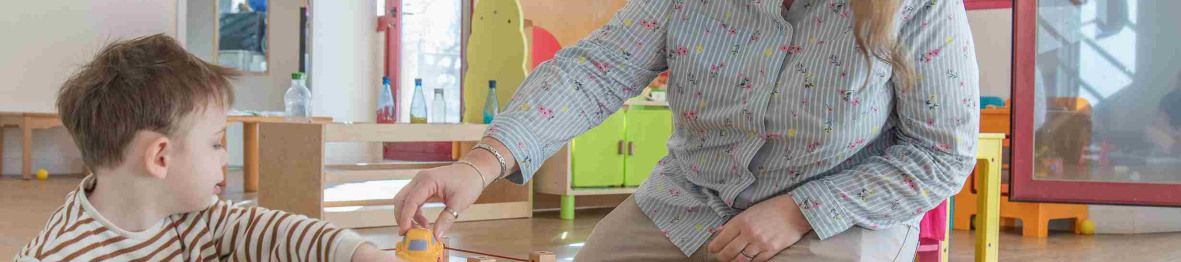 Une pro et un enfant en crèche en interaction 