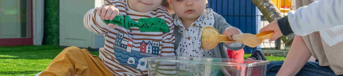Deux enfants et une pro dans le jardin en interaction 