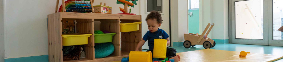 Un enfant en crèche qui joue sur un tapis d'éveil