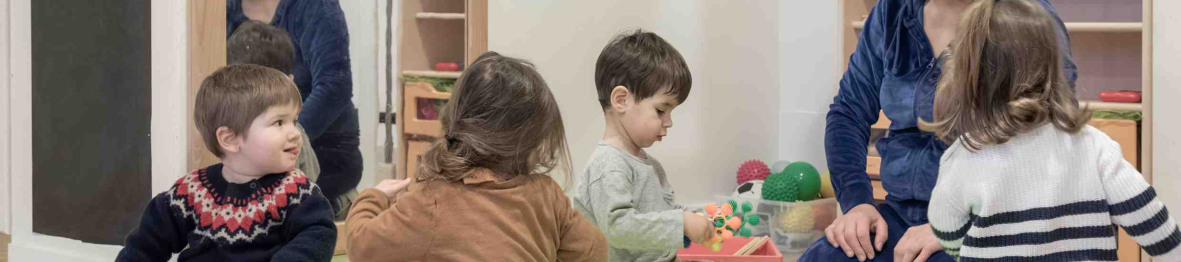 Une pro en crèche jouant avec un groupe d'enfants