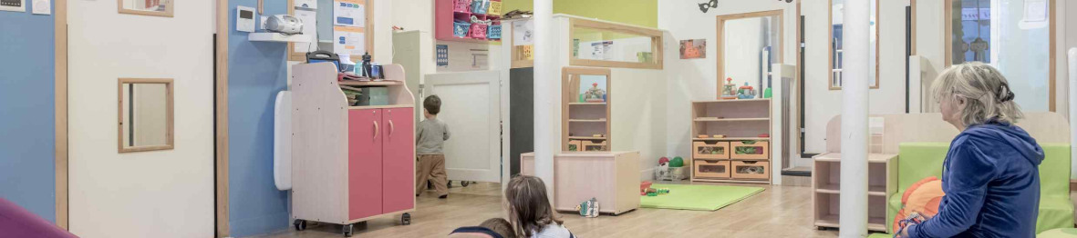 Une pro en crèche en interaction avec deux enfants 