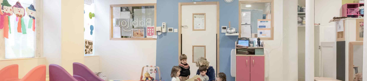 Une pro en crèche en interaction avec deux enfants 