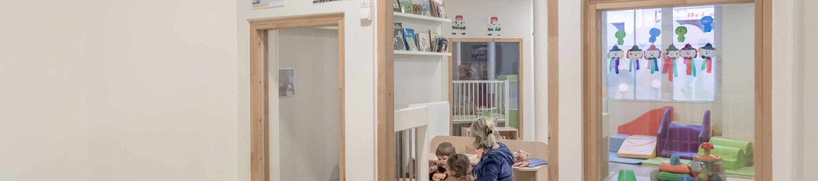 Une pro en crèche en interaction avec deux enfants 